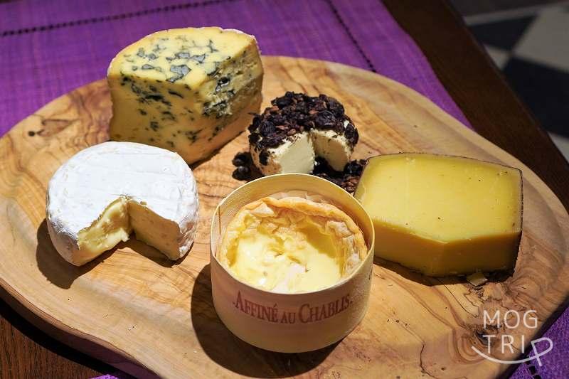 フランス産と北海道産の5種類のチーズが木のプレートにのせられ、テーブルに置かれている