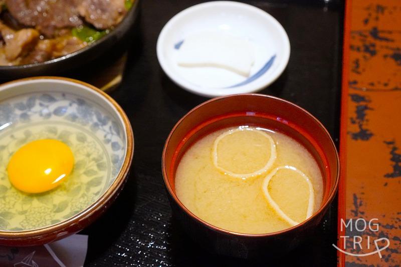函館にある「すき焼き専門店 阿さ利 本店」の、すき焼きランチセットの生卵と味噌汁