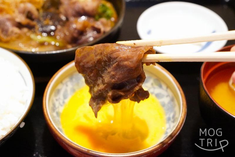 函館にある「すき焼き専門店 阿さ利 本店」の、すき焼きランチセットのお肉を箸で持ち上げている様子