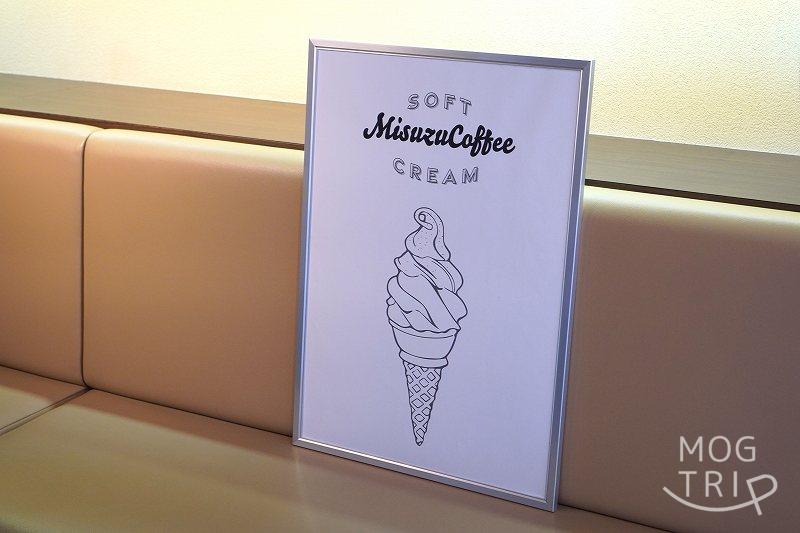 「函館美鈴珈琲 大門店」の店内ソファにソフトクリームのポスターが置かれている