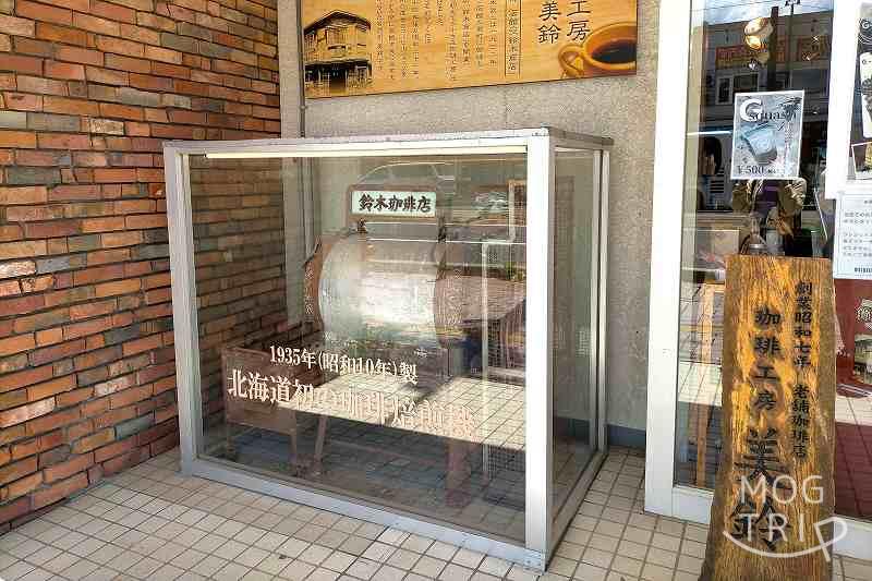北海道初のコーヒー焙煎機がガラスケースに入れられ、地面に置かれている
