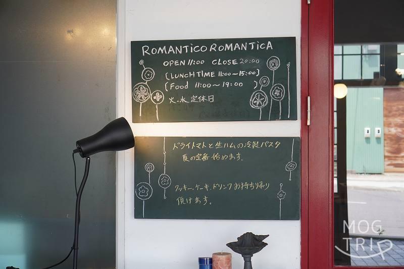 ロマンティコロマンティカの営業時間やメニューの説明が壁に貼られている