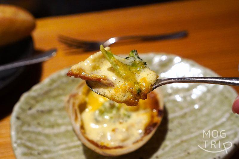 函館「欧風料理 紫ぜん」ホッキ貝のグラタンをスプーンですくった様子