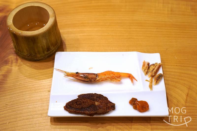 海鮮珍味の盛り合わせと竹酒がテーブルに置かれている
