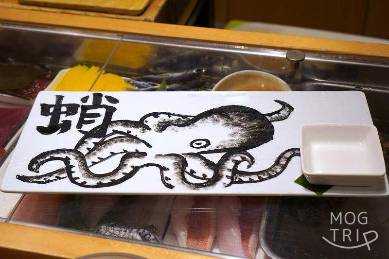 蛸の絵が描かれたプレートがネタケースの上に置かれている