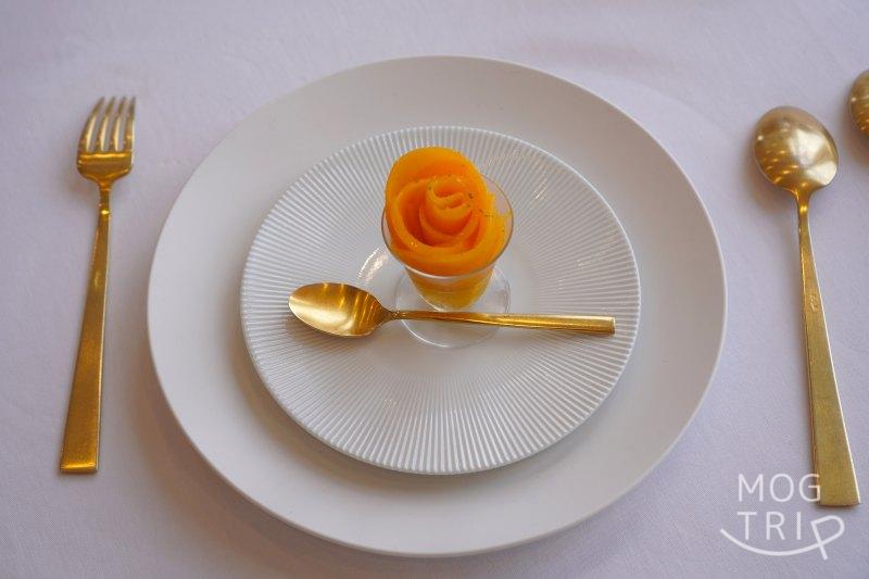マンゴーを花見に立てたデザートがテーブルに置かれている
