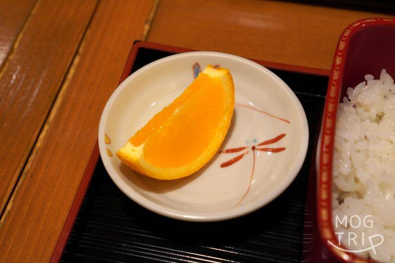小さくカットされたオレンジがテーブルに置かれている