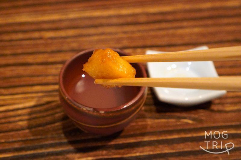 旭川「鮨みなと」のホタテを箸でスープに入れている様子