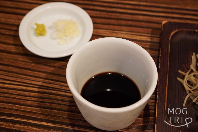 旭川「鮨みなと」の「手打ち蕎麦」のつゆと薬味がテーブルに置かれている