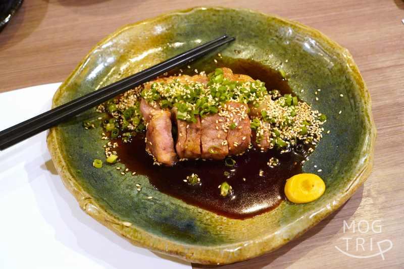 和菜酒房おりべの、旭川産 いも豚 肩ロースたれ焼きがテーブルに置かれている