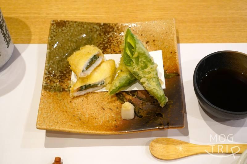 旭川「小西鮨」の羅臼産 銀宝（ギンポ） と甘唐辛子の天ぷらがテーブルに置かれている