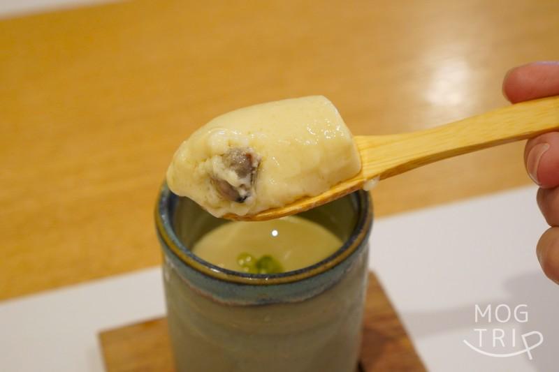 旭川「小西鮨」のしじみの茶碗蒸しをスプーンですくっている様子