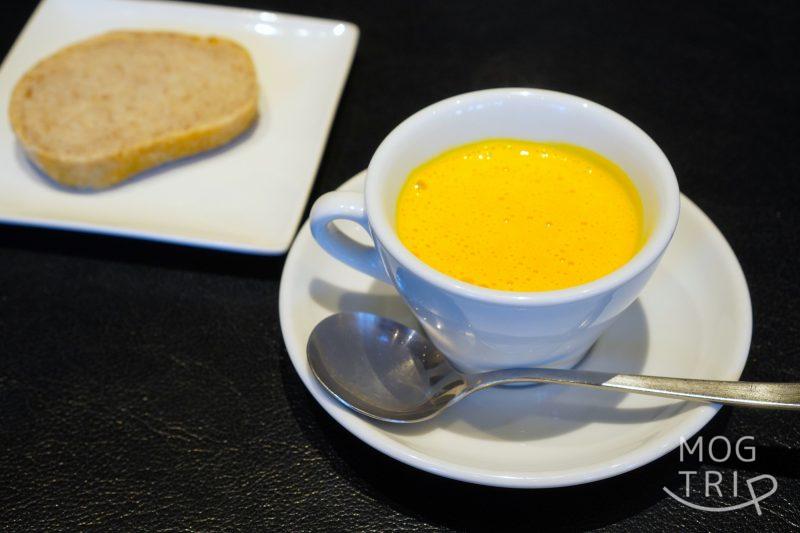 「P’tit salé（プティ サレ）」のかぼちゃスープとパンがテーブルに置かれている