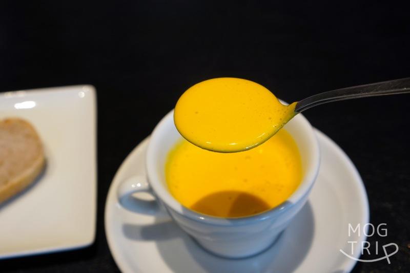 「P’tit salé（プティ サレ）」のかぼちゃスープをスプーンですくっている様子